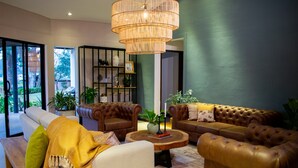 A modern living room with leather sofas, a wooden coffee table, and a large wicker chandelier. - Monarch Campestre (El Carmen de Viboral)