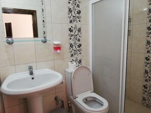 A bathroom with a sink, toilet, and a glass shelf. - PINAR OTEL (Amasra)