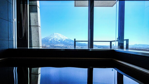 Blick auf den Fuji durch ein Fenster mit Metallrahmen und Glas.