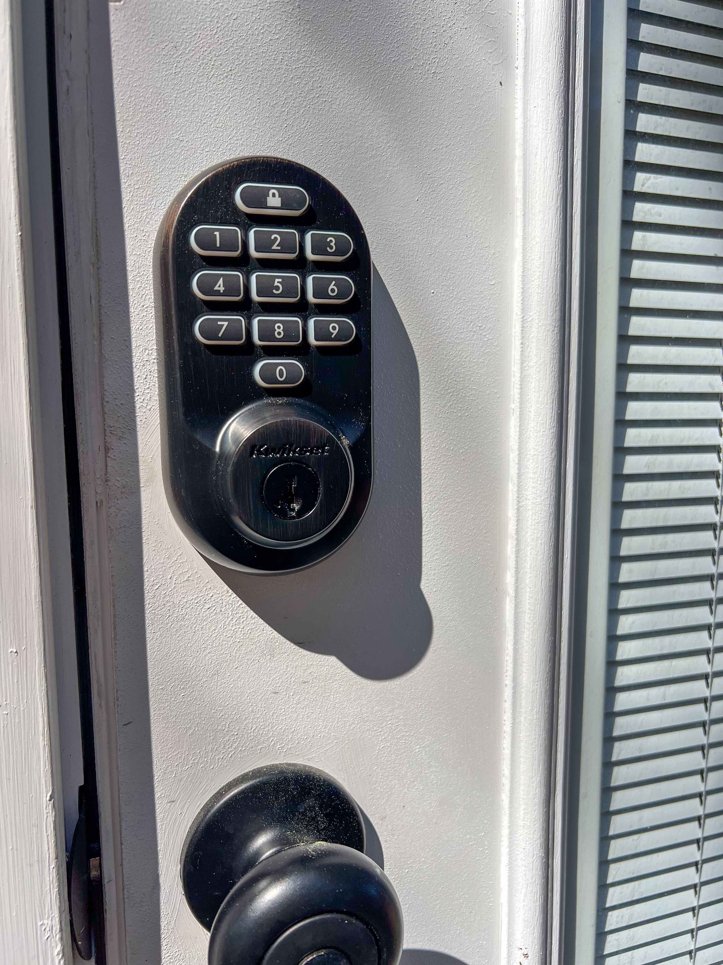 A door lock with a keypad and a keyhole.