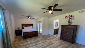 A bedroom with a wooden bed, a ceiling fan, and a dresser. - Bayside Cove Retreat: Your Coastal Escape (Shalimar)