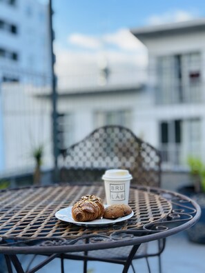 Une table en métal avec une assiette de nourriture et une tasse de café.