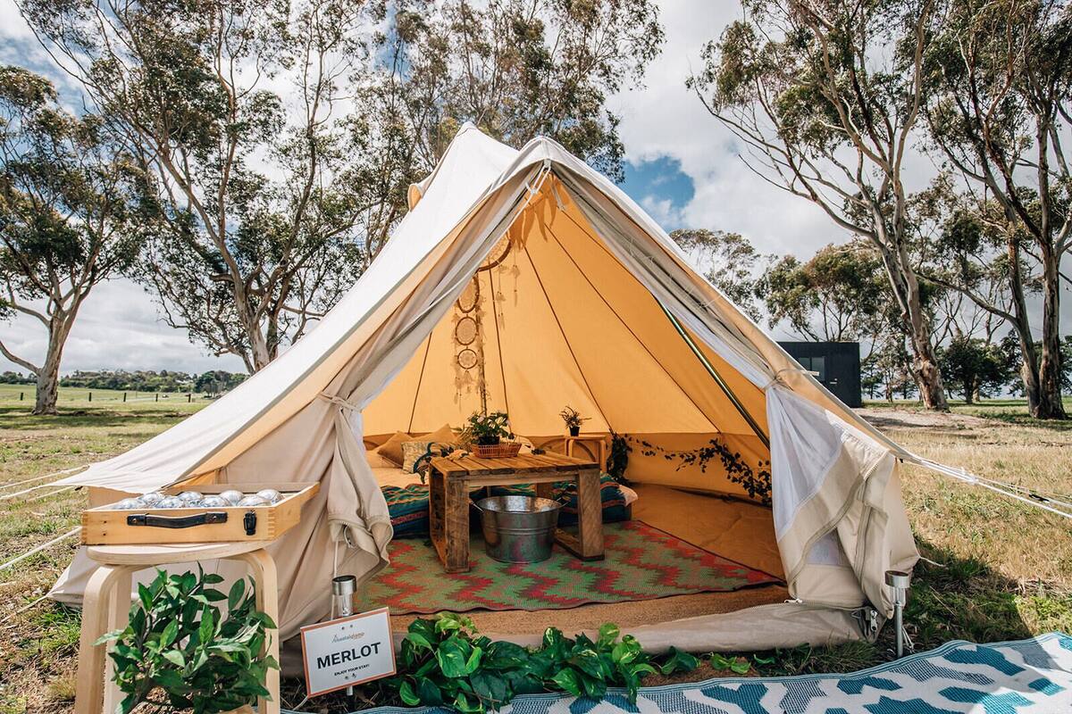 A Merlot tent with a table, chairs, and a sign.