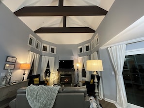 A living room with a fireplace, a sofa, a TV, and a lamp.