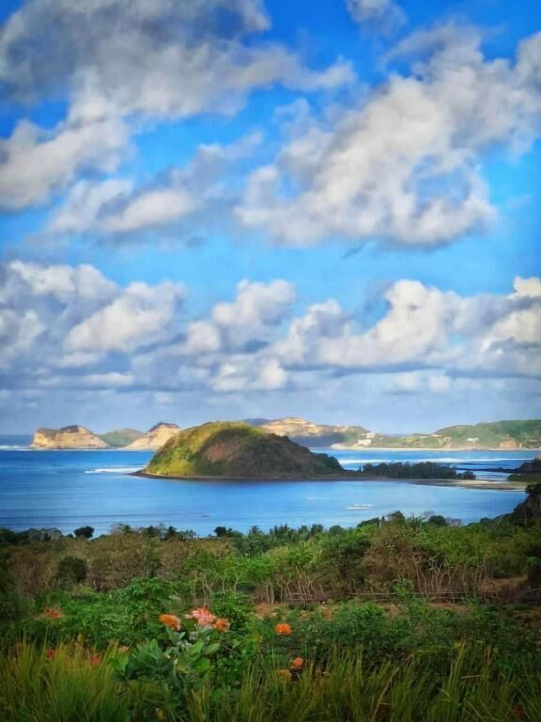 Un paisaje costero con una isla destacada y cielo despejado.