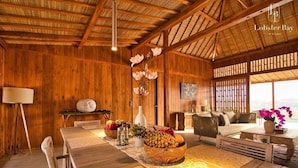 A wooden interior with a dining area, a sofa, and a TV. - Lobster Bay Resort  (Mertak)