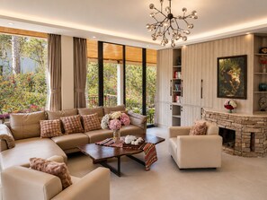 A modern living room with a sofa set, a coffee table, a fireplace, and a bookshelf. - Kim Ngan Hills Resort (Da Lat)
