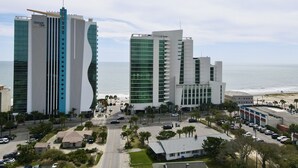 A modern hotel with a unique wavy facade, located near a beach with a view of the ocean. - Sea View Home 6 bed 3bedroom-garage near boardwalk (Myrtle Beach)