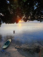 Una superficie acuática tranquila con un bote y un muelle.