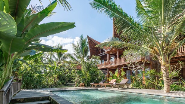 A resort with a pool, wooden deck, and lush greenery. - D&B Mandala Villas (Ubud)