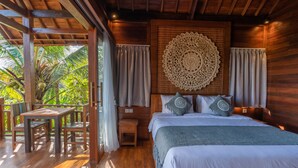 A wooden room with a bed, a table, and chairs. - D&B Mandala Villas (Ubud)
