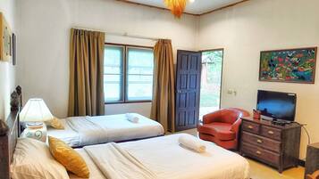 A hotel room with two beds, a television, a desk, and a painting on the wall.