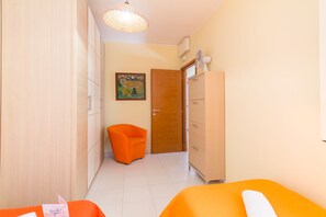 A hotel room with a bed, a chair, a wardrobe, a door, and a painting on the wall. - Villetta Relax with pool in residence, Melendugno, Italy (Melendugno)