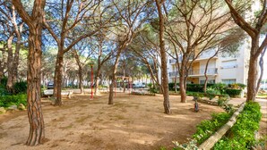 A park with trees, benches, and a playground. - WELCS APARTAMENTO 126 PDA cerca del puerto (Platja d´Aro)