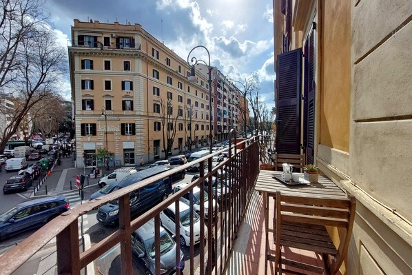 A balcony with a view of a busy street and buildings.