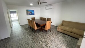 Un comedor con una mesa y sillas, un ventilador de techo, un equipo de aire acondicionado y un cuadro en la pared.