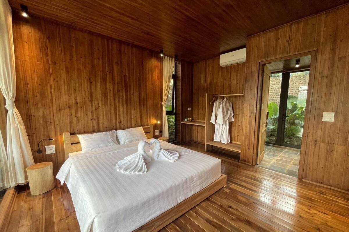 Un dormitorio con paneles de madera, una cama grande, una mesita de noche y un armario.