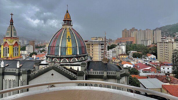 A cityscape with a prominent colorful church dome, a smaller church with a cross, and residential buildings. - Apartment in Caracas  (Caracas)