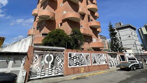 A tall, multi-story building with a unique architectural design featuring balconies on each floor. - Apartment in Caracas  (Caracas)