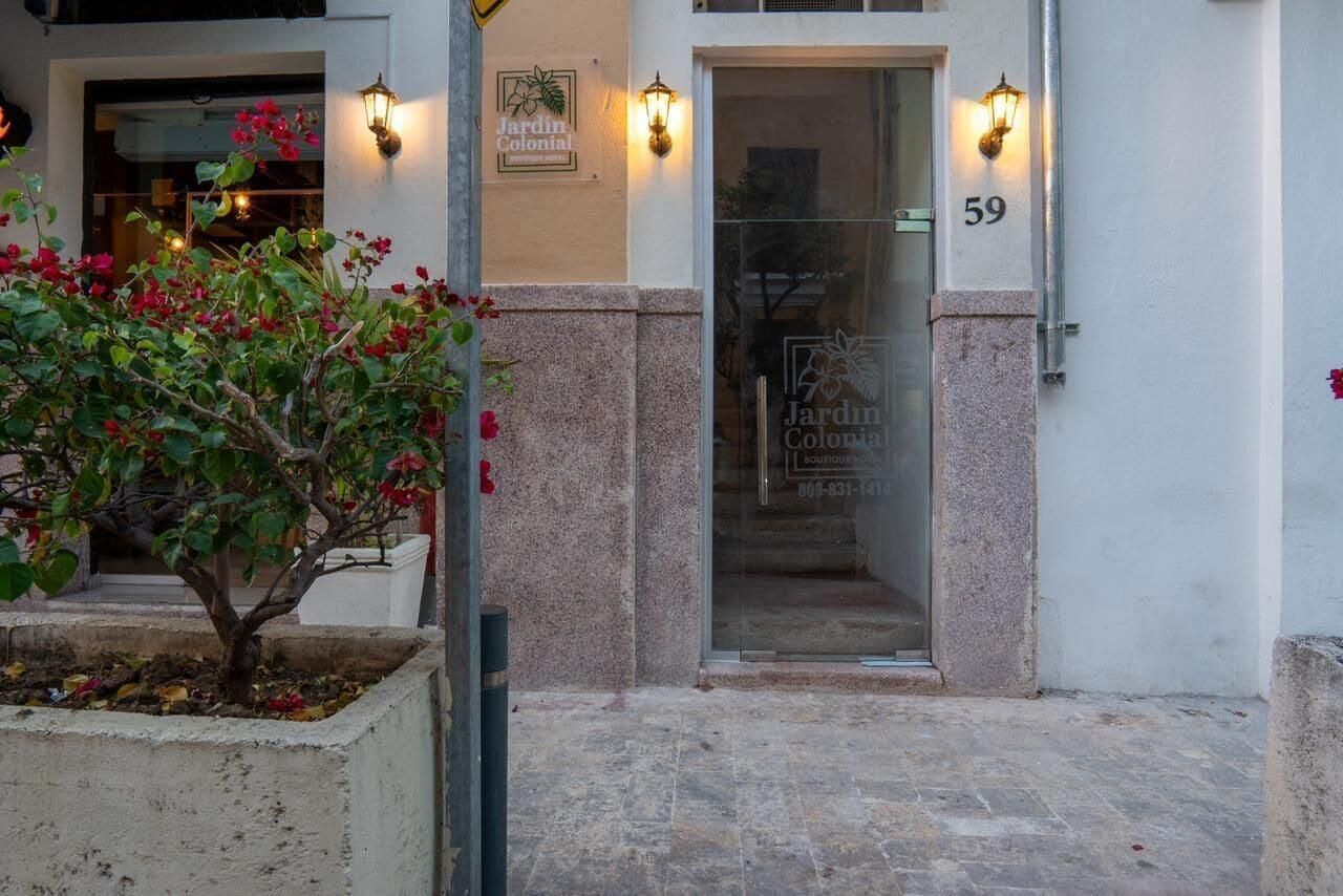 A building entrance with a glass door, a number '59' above it, and a sign 'Jardin Colonial.'