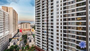 A high-rise residential building with multiple balconies and a view of the surrounding urban area. - Golden Mansion Apartments Phu Nhuan (Ho Chi Minh City)