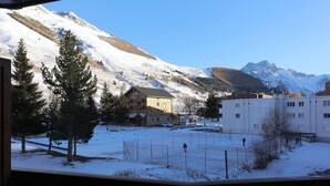 A snow-covered outdoor area with buildings, including a lodge and a white building, in a mountainous region. - Studio 4 ppl, splendid view from balcony (Les Deux Alpes)
