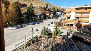 A view of a street with buildings, a wooden deck, and solar panels.