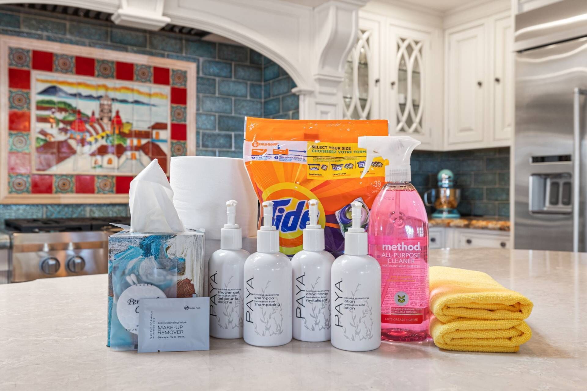 A kitchen counter with various cleaning products and a towel.
