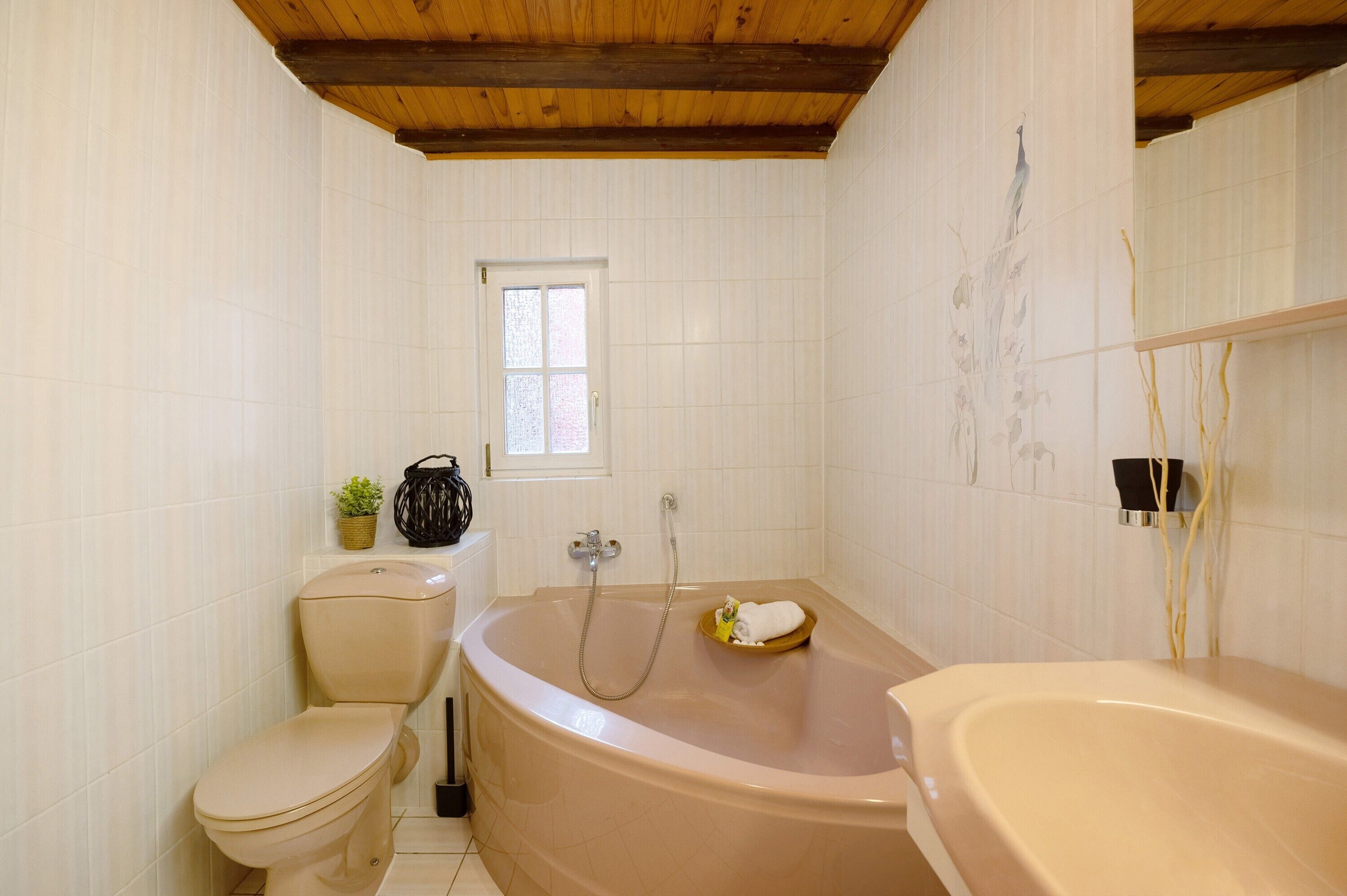 Un bagno con il water, una vasca e una finestra.