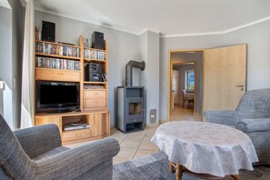 A living room with a television, bookshelf, and a fireplace.