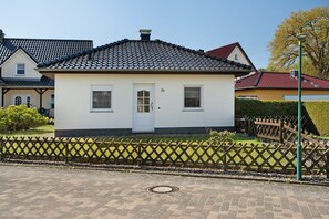 A single-story house with a tiled roof, a front door, and a small porch.