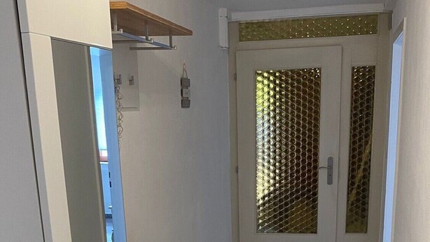 A hallway with a white wardrobe, a wooden cabinet, and a tiled floor. - Apartment 'Am Sonnenberg' with Private Terrace and Wi-Fi (Reichelsheim (Odenwald))