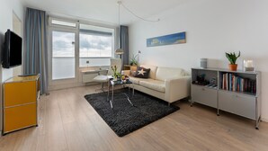 Una sala de estar moderna con sofá, mesa de centro y estantería.