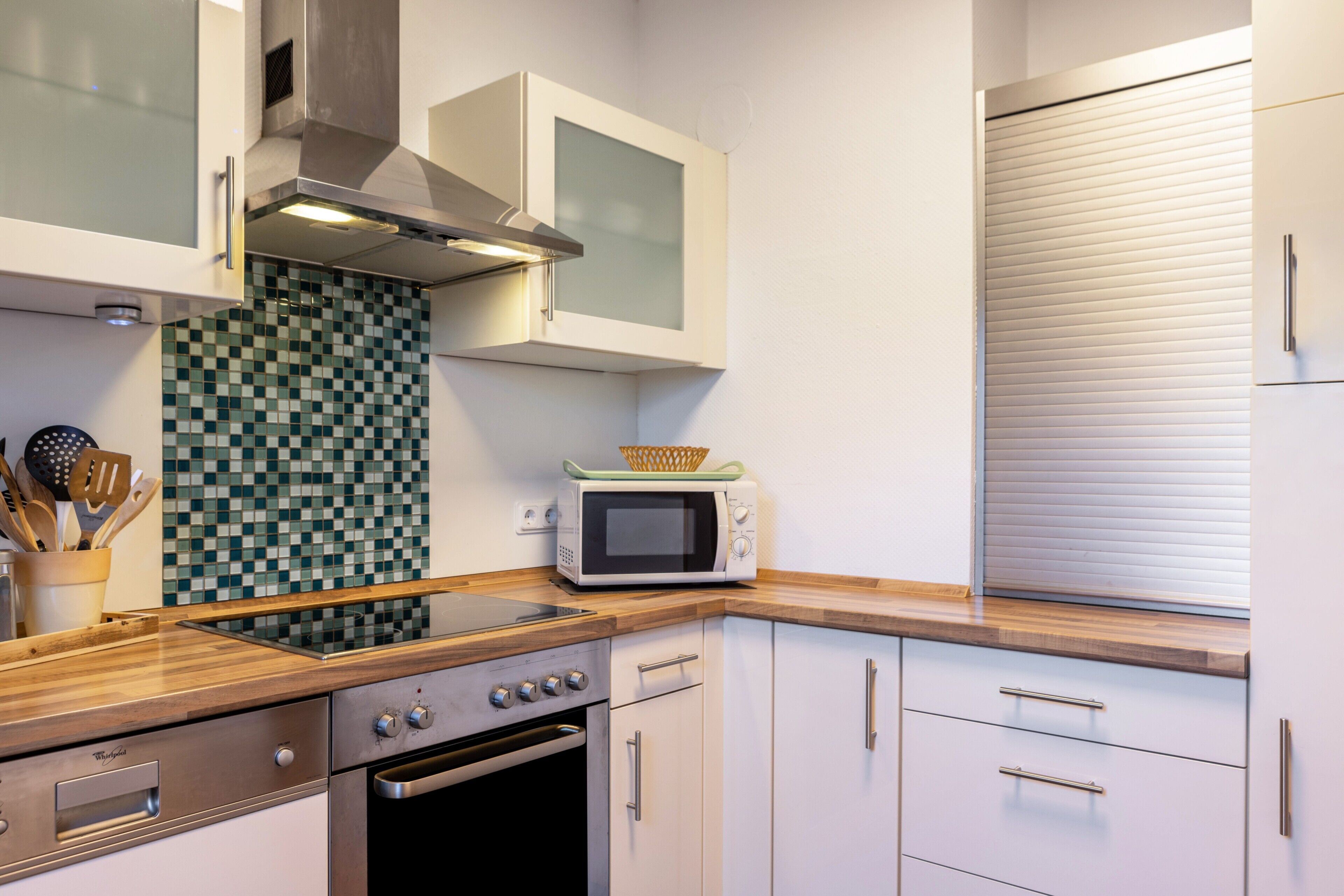 A kitchen with a microwave, oven, and stainless steel cabinets.
