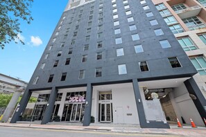Ein modernes Hotelgebäude mit einem markanten Eingang, großen Fenstern und einem gut sichtbaren Adressschild.