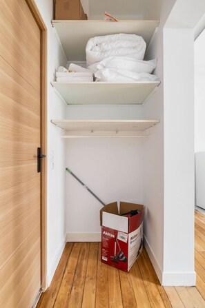 A storage closet with wooden flooring, white walls, and a door. - Modern 60m² Apartment Near Metro - Paris 12 (Paris)