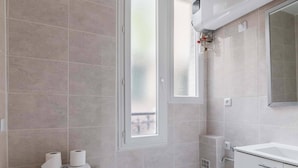 A modern bathroom with a toilet, sink, and shower area. - Modern 60m² Apartment Near Metro - Paris 12 (Paris)