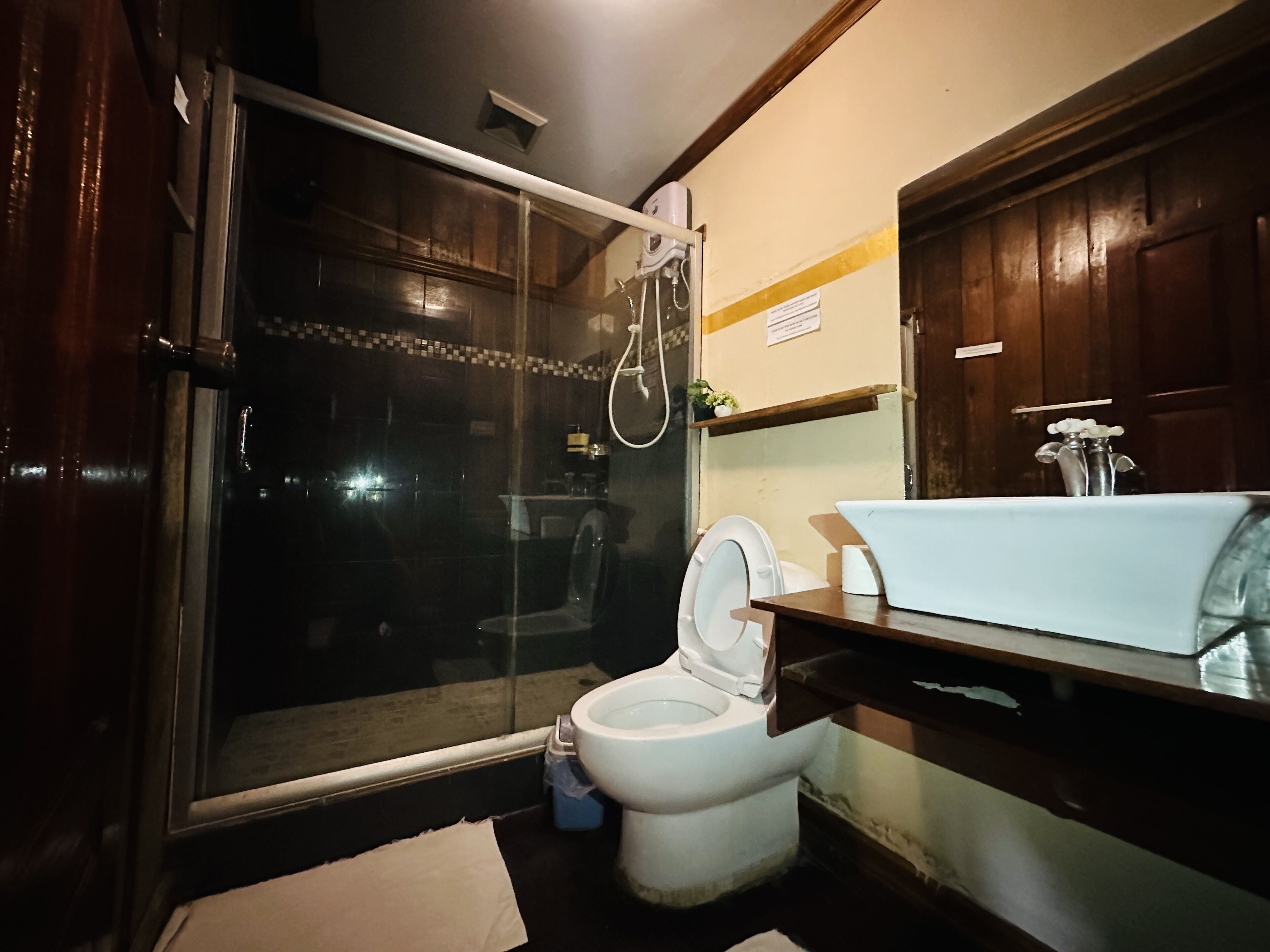 Un baño con inodoro, cabina de ducha y lavamanos.