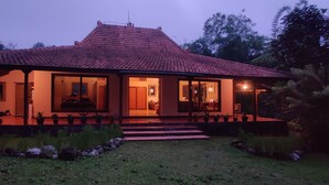 A two-story house with a tiled roof, large windows, and a well-maintained garden. - Private nature estate near Mt Merapi, Yogyakarta, stylish villa 4/6 persons (Kabupaten Sleman)