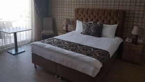 A hotel room with a large bed, a small table, and a chair. - Seda Park Otel (Biga)