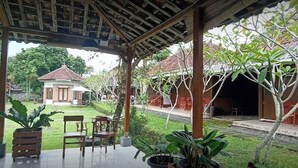 Un espacio al aire libre cubierto con mobiliario de madera y plantas en macetas.
