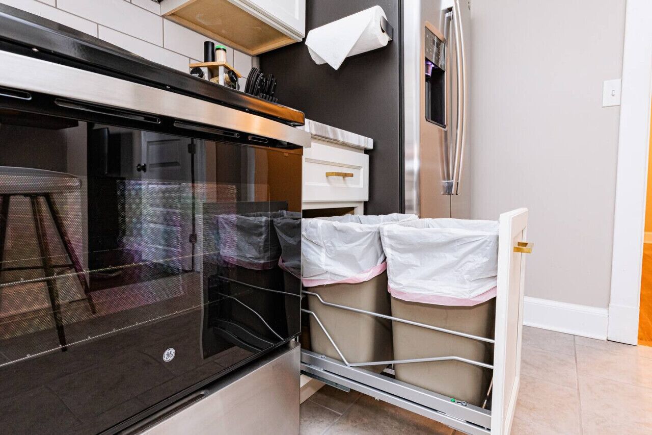Una cocina compacta con horno empotrado, una pequeña encimera y un refrigerador de acero inoxidable.
