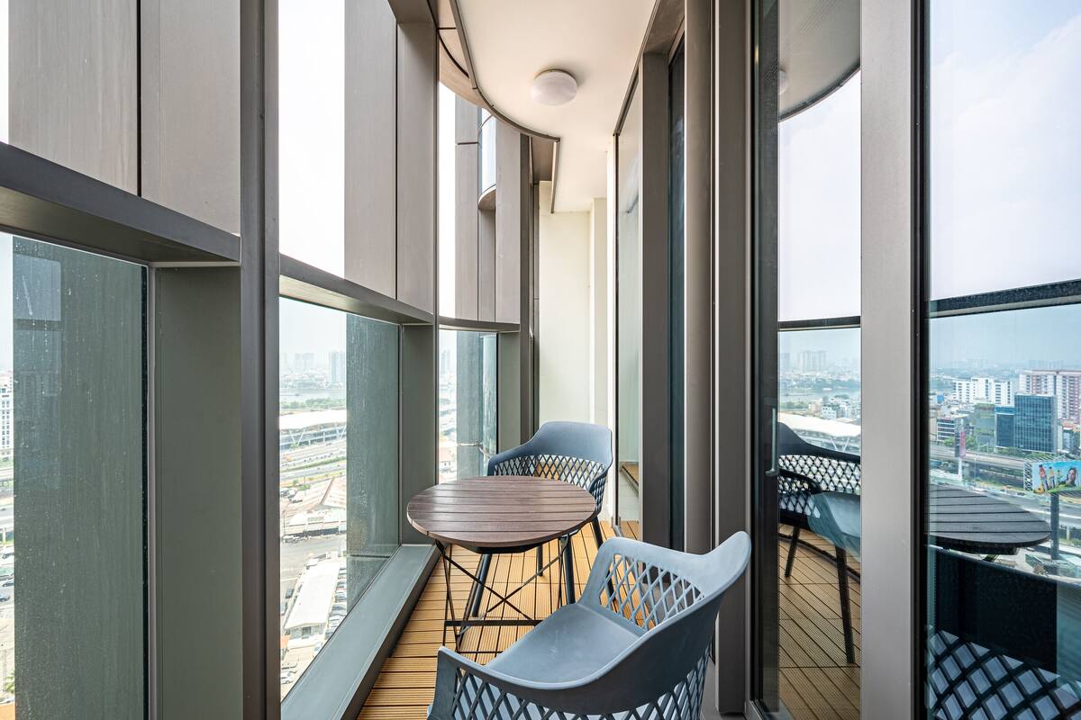 Un balcon avec un plancher en bois, deux chaises et une table.
