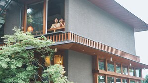 Un edificio moderno de dos pisos con ventanas amplias y un balcón.