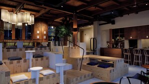 Un interior moderno con muebles de madera, mesas blancas y una zona de bar.
