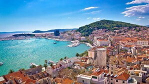 A coastal cityscape with historic architecture, a marina, and a hill in the background. - Modern Apartment With sea View (Podstrana)