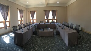 A conference room with a long table, chairs, and a projector. - Whispering Woods Resort (Thimphu)