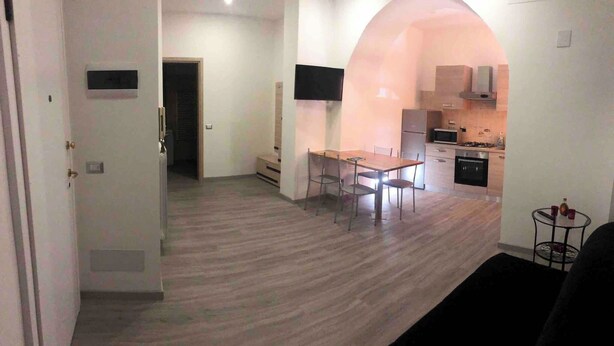 Un espace de vie compact comprenant un coin repas, une kitchenette et un aménagement à plan ouvert.