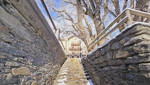 A stone staircase leading up to a building with a balcony. - Grand Hotel Ceresole Reale Studio Apartment (Ceresole Reale)