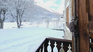 A snow-covered landscape with a wooden building and a balcony. - Grand Hotel Ceresole Reale Studio Apartment (Ceresole Reale)